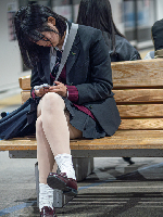 駅のベンチに座る制服を着た女の子達